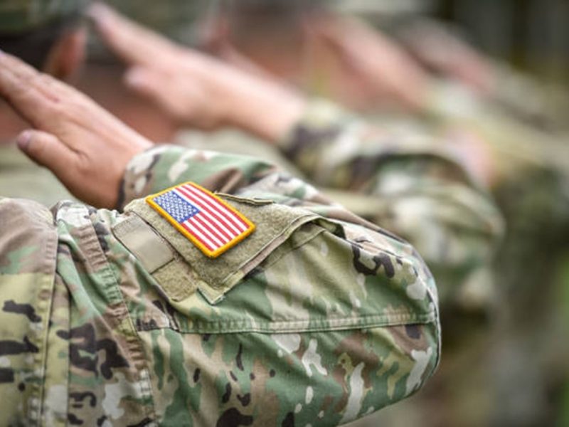 Detail shot with american flag on soldier uniform, giving the honor salute during military ceremony